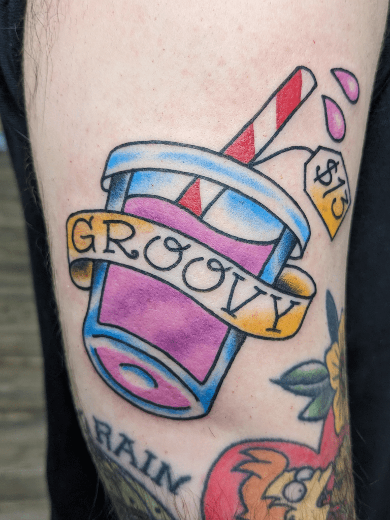 An American Traditional tattoo of a pink and purple smoothie with "groovy" on a banner. 